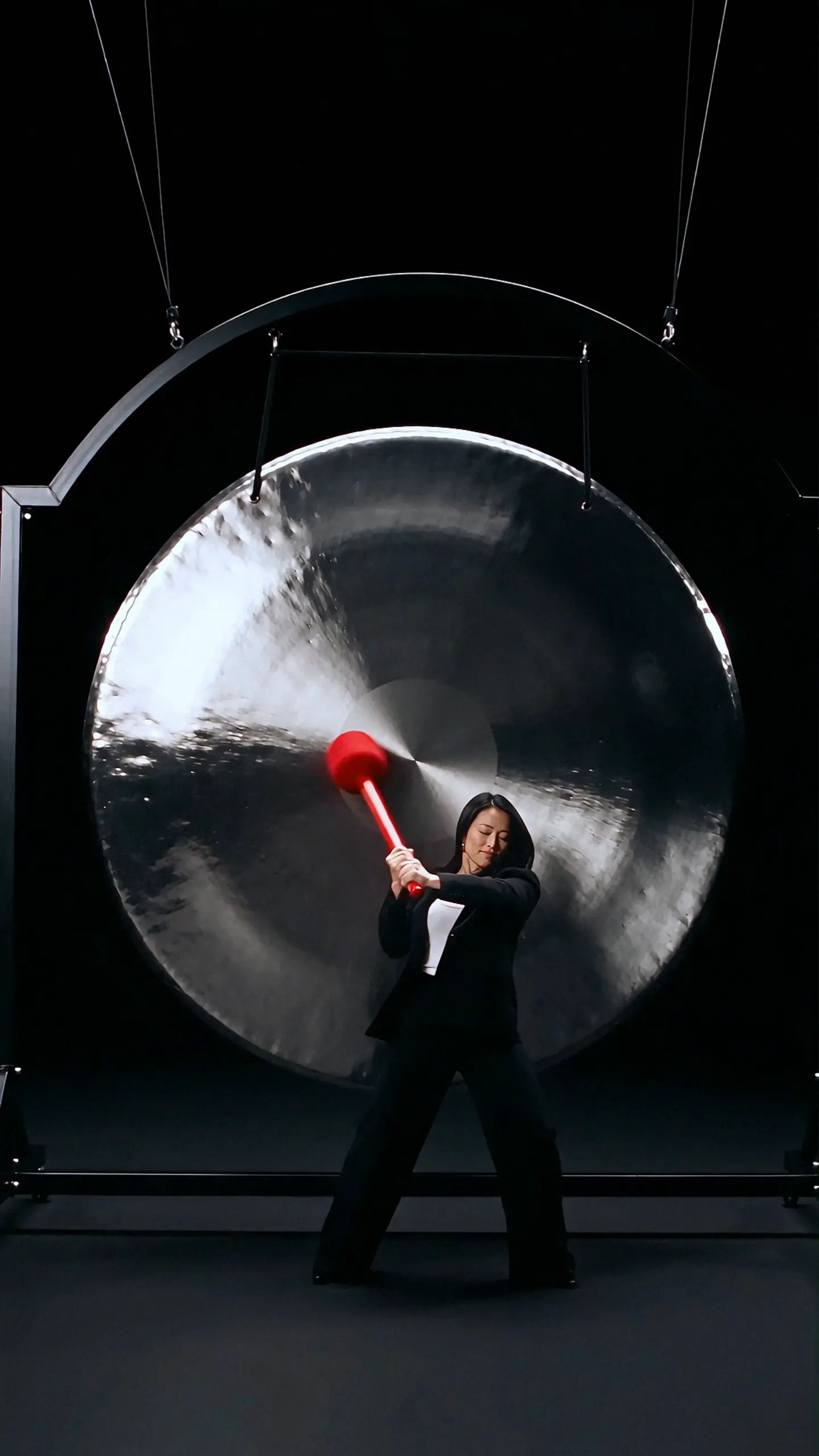 Woman striking a giant steel gong in the Coca-Cola Zero Sugar concept film