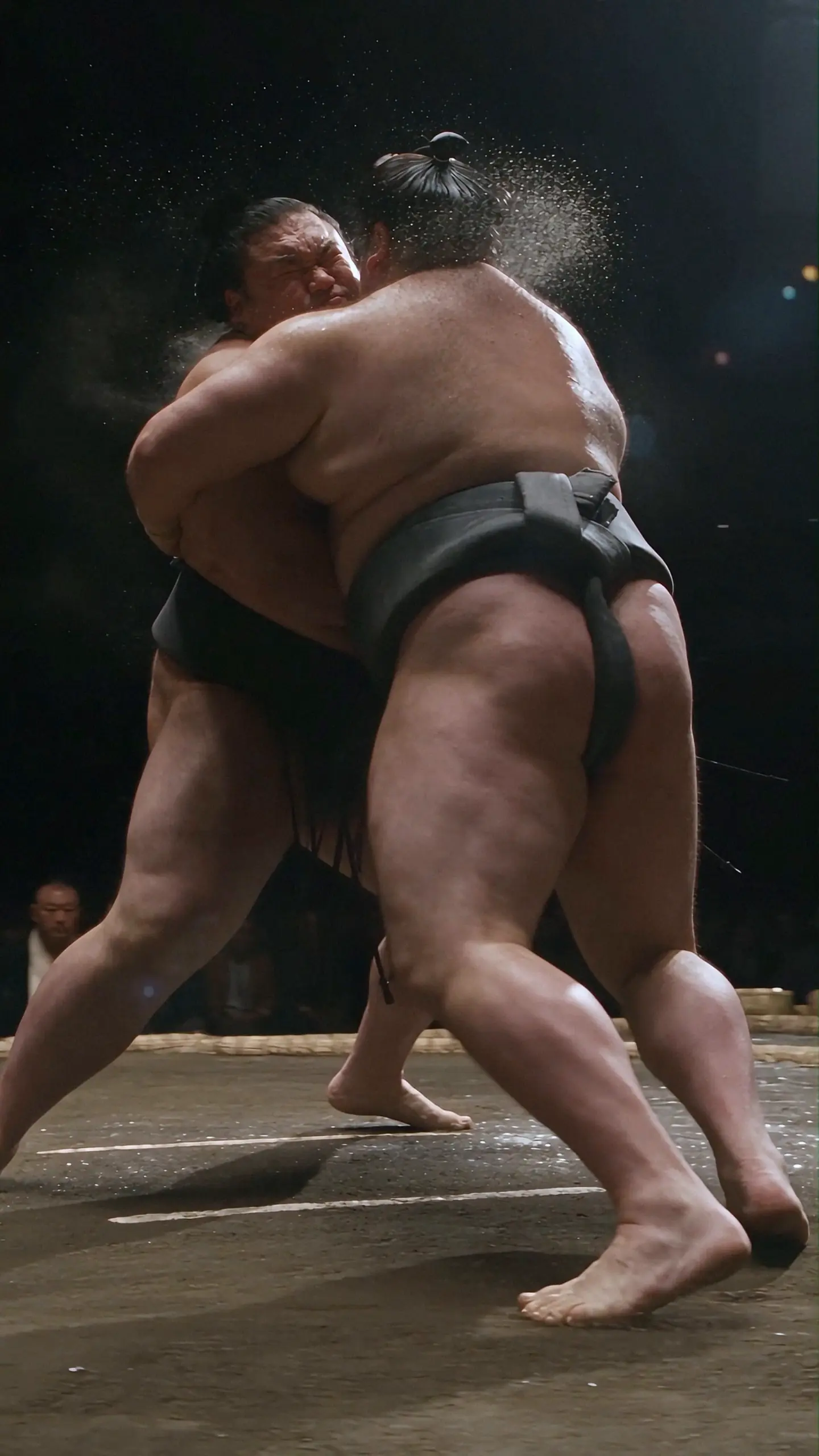 Two sumo wrestlers colliding in a cinematic action sequence